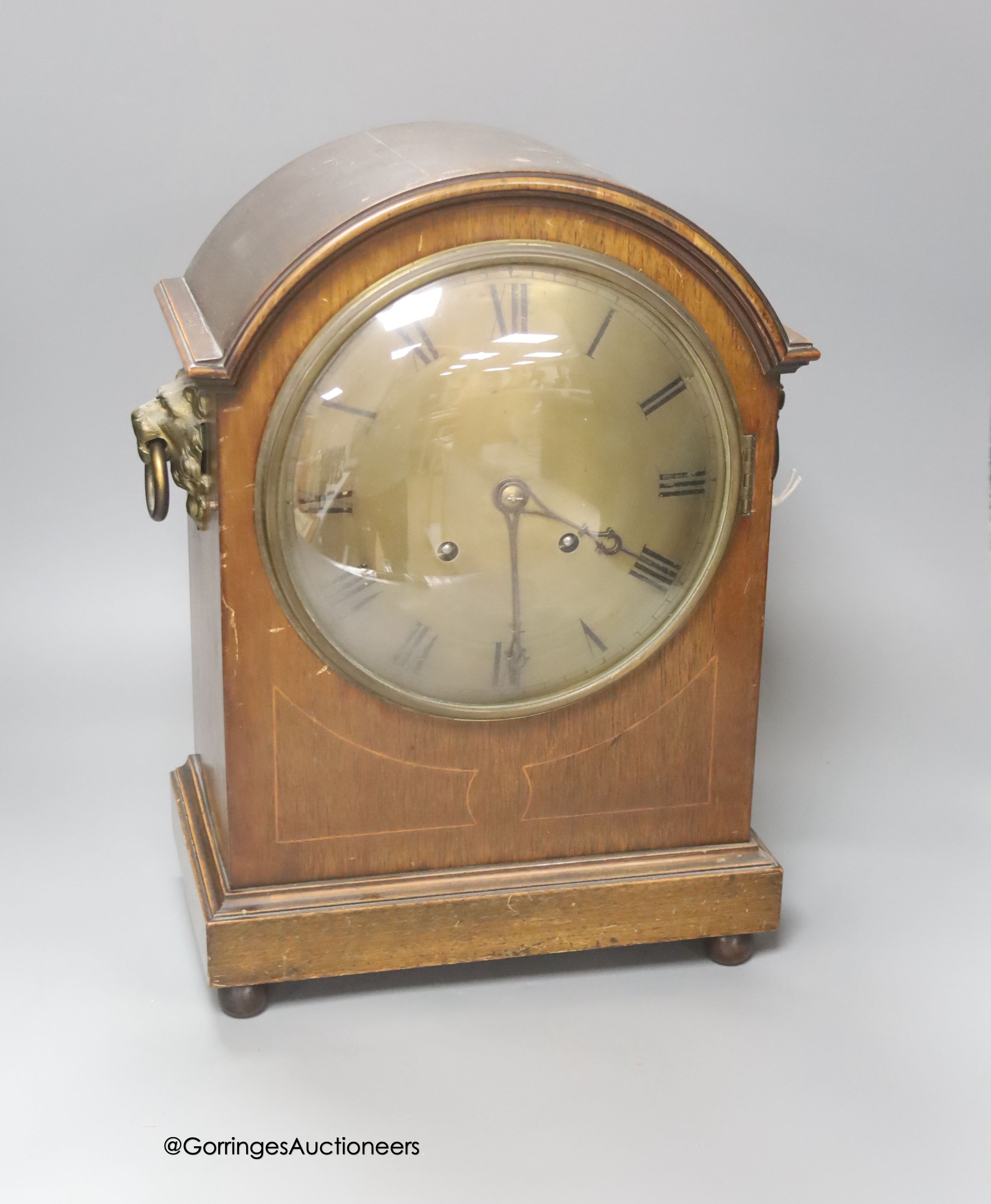 An Edwardian inlaid mahogany mantel clock, with lion mask ring handles, with key and pendulum, height 38cm